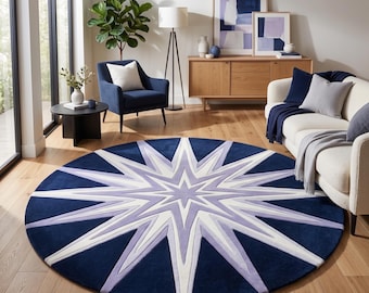 Puede incluir: Una alfombra circular grande con un fondo azul marino profundo y un diseño prominente de estrella de múltiples puntas en tonos lavanda claro y blanco brillante, que irradia desde el centro hacia los bordes.