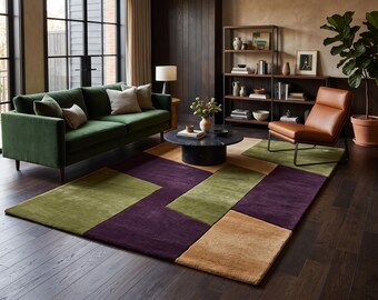 Puede incluir: Una alfombra rectangular con un patrón geométrico de bloques de color en tonos morado oscuro, verde oliva y bronceado. La alfombra tiene una textura de pelo corto y está compuesta por secciones angulares distintas que crean un efecto visual moderno.
