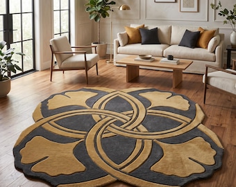 Puede incluir: Una alfombra circular con un fondo gris oscuro y un gran patrón de hojas de ginkgo de color amarillo dorado. El diseño consta de cuatro hojas de ginkgo estilizadas y superpuestas, dispuestas en un motivo circular simétrico.