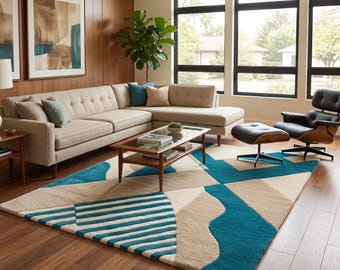 Puede incluir: Una alfombra rectangular grande con un patrón geométrico en tonos verde azulado y beige. El diseño incluye rayas llamativas, bloques de colores sólidos y formas curvas, creando una superficie texturizada sobre el suelo de madera.