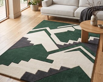 Puede incluir: Una alfombra rectangular con un patrón geométrico de grandes formas entrelazadas en verde bosque profundo, blanco roto y gris carbón. El diseño consta de líneas angulares nítidas y bordes escalonados que crean una composición abstracta.