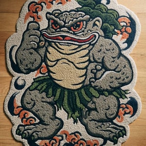 May include: A rug shaped like a cartoonish, muscular frog with red eyes, a green skirt, and a tan belly. The rug has a light beige background with orange and black accents. The word "RUG" is visible at the bottom.