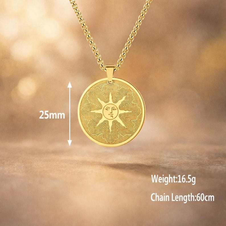 May include: A gold-colored pendant necklace featuring a circular pendant with a sun design. The pendant is 25mm in diameter and is suspended from a 60cm chain. The pendant weighs 16.5g.