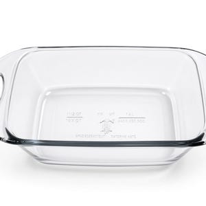 Könnte beinhalten: Eine rechteckige Auflaufform aus klarem Glas mit integrierten Seitengriffen. Der Boden der Form weist geprägte Schriftzüge auf, darunter 1 1/2 QT, 1 1/4 QT, 1.4 L und weitere Markierungen. Die Form hat eine glatte, transparente Oberfläche und abgerundete Ecken.