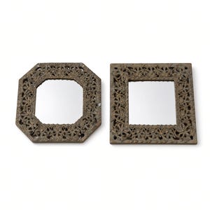 May include: Two wall mirrors with dark bronze-toned metal frames featuring intricate floral and leaf relief patterns. One mirror has an octagonal shape, while the other is square. Both frames have a textured, aged finish with visible detailing.