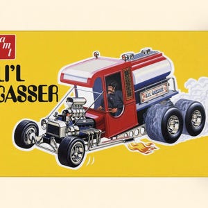 May include: A yellow rectangular box featuring an illustration of a red and blue Li'l Gasser hot rod truck with a large engine, dual rear wheels, and flames coming from the side exhaust. The AMT logo is in the top left corner.