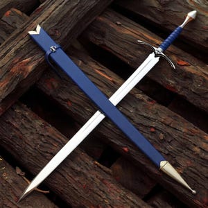 Puede incluir: Una espada de metal plateado con empuñadura envuelta en azul y una vaina azul a juego. La espada presenta una hoja puntiaguda, una guarda con gavilanes curvos y un pomo metálico. La vaina tiene herrajes de metal plateado en ambos extremos.