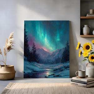 May include: A canvas print depicting a winter scene with a river, snow-covered mountains, and evergreen trees beneath the aurora borealis. The sky is a blend of teal, pink, and purple. The artwork is displayed indoors, next to a vase of sunflowers.