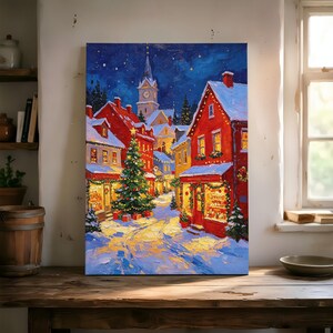 May include: A vertical canvas print depicting a snowy winter village scene at night. The painting features bright red buildings with snow-covered roofs, a large decorated Christmas tree in the center, and a tall church steeple under a starry blue sky.