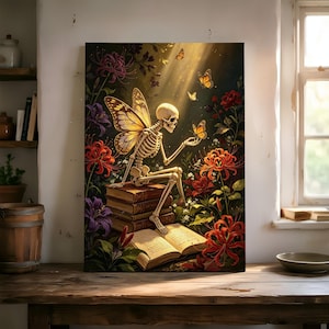 Könnte beinhalten: Ein rechteckiger Wandkunstdruck, der ein Skelett mit Schmetterlingsflügeln zeigt, das auf einem Bücherstapel sitzt und einen Schmetterling hält. Die Szene ist von roten Spinnenlilien und violetten Blumen umgeben, beleuchtet durch Licht.
