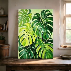 May include: A rectangular canvas painting featuring a cluster of large monstera leaves in various shades of vibrant green and lime yellow. The artwork displays thick, textured brushstrokes and distinct leaf perforations on a light green background.
