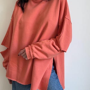 Abrikooskatoenen sweater met gescheurde elleboog