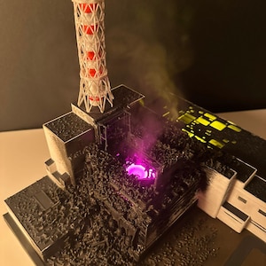 May include: A detailed model of a nuclear power plant, with a lattice tower featuring red detailing. The model has a dark, textured surface with a glowing purple core, and emits a smoky effect. The overall theme is a miniature replica.