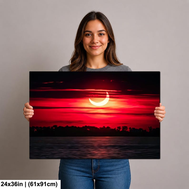 Pode incluir: Impress&atilde;o em tela de um vibrante p&ocirc;r do sol vermelho com um sol em forma de crescente. A obra de arte, medindo 61x91cm, mostra um c&eacute;u dram&aacute;tico sobre um corpo de &aacute;gua escura, criando um contraste visual marcante. O tema geral &eacute; natureza e paisagem.