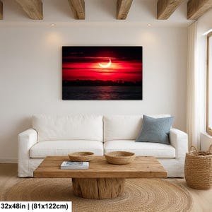Pode incluir: Impress&atilde;o em tela de um vibrante p&ocirc;r do sol vermelho sobre a &aacute;gua, com um sol em forma de crescente. A obra de arte mede 81x122cm. A cena inclui uma silhueta escura de &aacute;rvores no horizonte.