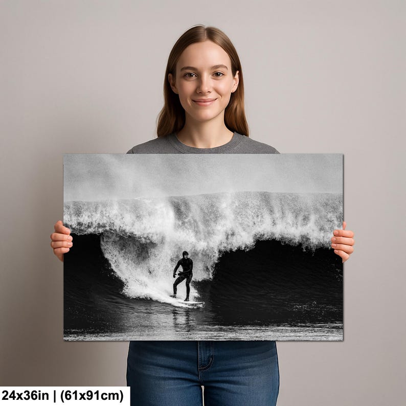 K&ouml;nnte beinhalten: Schwarz-Wei&szlig;-Leinwanddruck eines Surfers auf einer Welle. Das Kunstwerk misst 61x91cm (24x36 Zoll). Der Surfer, in einem schwarzen Neoprenanzug, reitet auf einem wei&szlig;en Surfbrett. Die Welle bricht und erzeugt eine dramatische Szene.