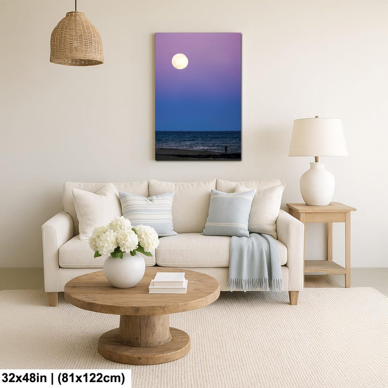 May include: A canvas print of a moonlit beach scene. The artwork features a large, bright moon in a purple and blue sky, with the ocean and a silhouetted figure on the shore. The canvas measures 32x48 inches.
