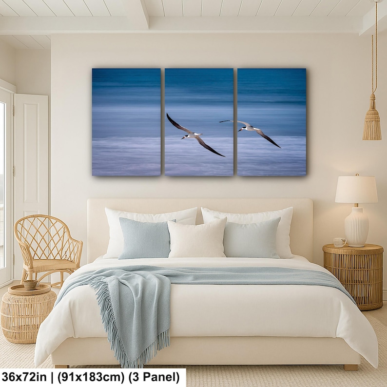 May include: A three-panel canvas print featuring two seabirds in flight over a blurred blue ocean. The artwork is 36x72 inches in size, perfect for a bedroom or living room. The birds have black wings and white bodies, creating a striking contrast against the blue.