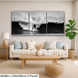 K&ouml;nnte beinhalten: Schwarz-wei&szlig;-Triptychon-Leinwandbild mit einem Surfer auf einer Welle. Das Kunstwerk misst 102x229cm und zeigt einen Surfer in einem schwarzen Neoprenanzug. Die Welle bricht und erzeugt einen Kontrast zwischen dunklem Wasser und wei&szlig;em Schaum.