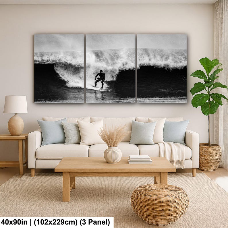K&ouml;nnte beinhalten: Schwarz-wei&szlig;-Triptychon-Leinwandbild mit einem Surfer auf einer Welle. Das Kunstwerk misst 102x229cm und zeigt einen Surfer in einem schwarzen Neoprenanzug. Die Welle bricht und erzeugt einen Kontrast zwischen dunklem Wasser und wei&szlig;em Schaum.