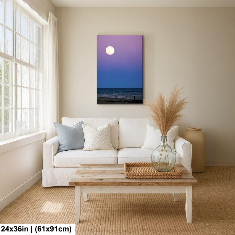 May include: A canvas print depicting a nighttime beach scene. The artwork features a gradient sky of purple and blue, a full moon, and the ocean. The dimensions are 24x36 inches (61x91cm).