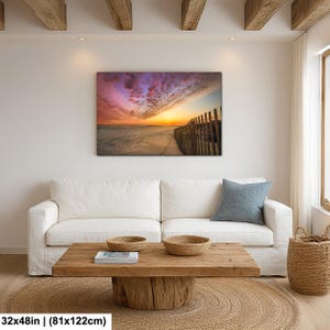 Peut inclure: Impression sur toile d'une sc&egrave;ne de plage au coucher du soleil. Le ciel est rempli de couleurs vives de rose, de violet et d'orange. Une cl&ocirc;ture en bois longe la plage, dimensions 81x122cm.