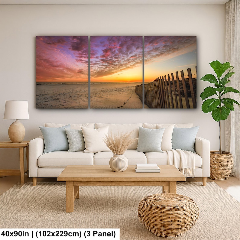 Peut inclure: Impression sur toile en trois panneaux repr&eacute;sentant une sc&egrave;ne de plage au coucher du soleil. Le ciel est rempli de teintes roses, violettes et orang&eacute;es. Une cl&ocirc;ture en bois longe la plage. Dimensions : 102x229cm.