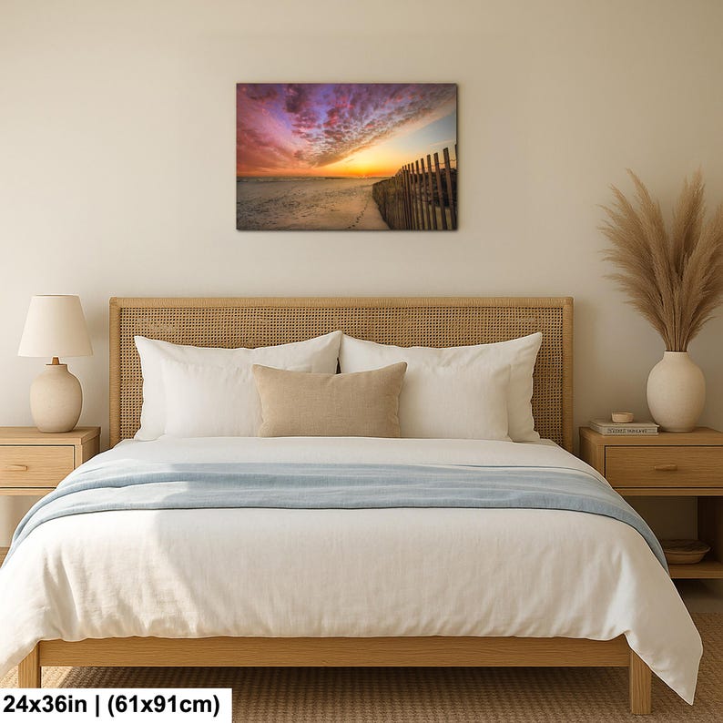 Peut inclure: Impression sur toile encadr&eacute;e d'un coucher de soleil vibrant sur une plage, avec des nuances de violet, d'orange et de jaune dans le ciel. L'&oelig;uvre mesure 61x91cm et pr&eacute;sente une cl&ocirc;ture en bois le long du rivage.