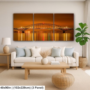 May include: A three-panel canvas print depicting a bridge at night, with warm golden hues and reflections in the water. The bridge is lit with lights, and the overall scene evokes a sense of tranquility. The print measures 40x90 inches.