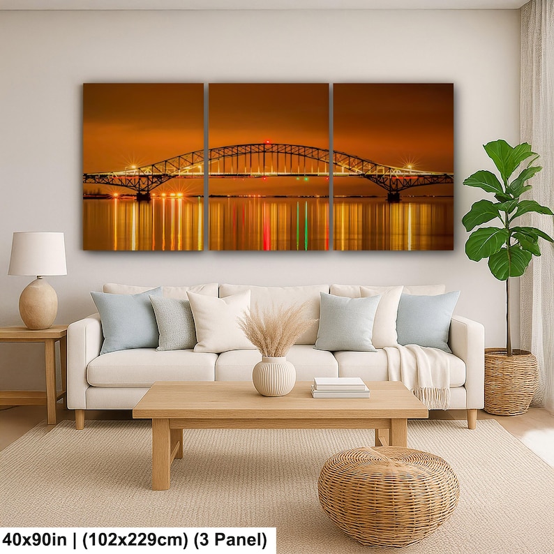 May include: A three-panel canvas print depicting a bridge at night, with warm golden hues and reflections in the water. The bridge is lit with lights, and the overall scene evokes a sense of tranquility. The print measures 40x90 inches.