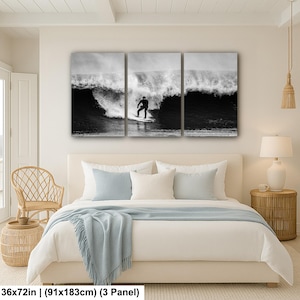 K&ouml;nnte beinhalten: Schwarz-wei&szlig;es Triptychon-Leinwandbild mit einem Surfer, der eine Welle reitet. Das Kunstwerk wird &uuml;ber einem Bett in einem Schlafzimmer gezeigt. Die Ma&szlig;e betragen 91x183cm.