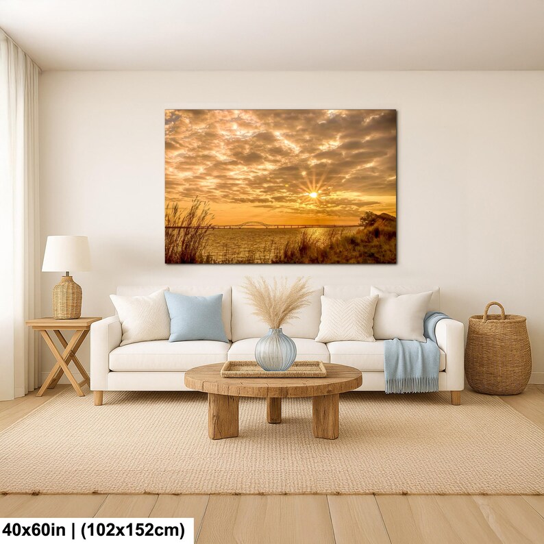 May include: A large canvas print depicting a sunset over a body of water, with a bridge in the distance. The sky is filled with golden clouds, and the sun is shining brightly. The print measures 40x60 inches (102x152cm).