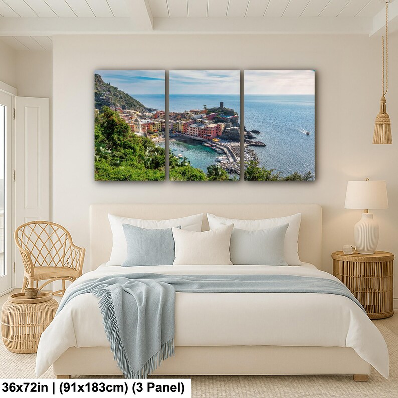 May include: A three-panel canvas print depicting a coastal Italian village. The artwork showcases colorful buildings, a harbor with boats, and a tower on a rocky outcrop, set against a blue sea and sky. The dimensions are 36x72 inches.
