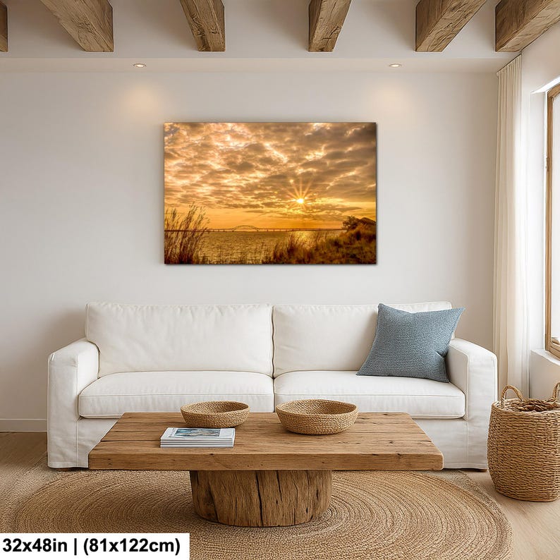 May include: A large rectangular canvas print depicting a sunset over a body of water. The sky is filled with golden clouds, and the sun's rays burst through. The print measures 32x48 inches (81x122cm).