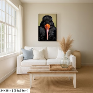 May include: A canvas print featuring a close-up of a black bird with an orange beak and a pinkish-red tip. The bird's feathers are dark and textured. The artwork is 24x36 inches.