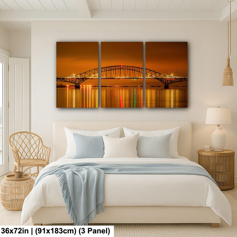 May include: A three-panel canvas print depicting a bridge at night, with the bridge's lights reflected in the water below. The artwork measures 36x72 inches. The color palette is dominated by warm oranges and yellows, creating a serene and atmospheric scene.