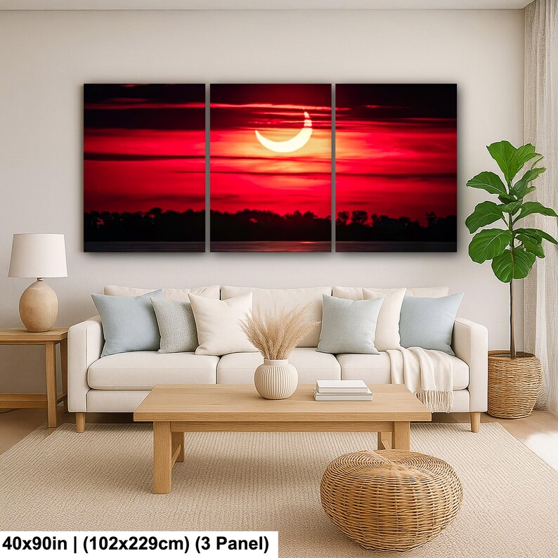Pode incluir: Impress&atilde;o em tela de tr&ecirc;s pain&eacute;is retratando um p&ocirc;r do sol vermelho vibrante com um eclipse parcial. A obra de arte, medindo 102x229cm, mostra um c&eacute;u dram&aacute;tico sobre uma silhueta escura de &aacute;rvores e &aacute;gua. A imagem &eacute; dividida em tr&ecirc;s pain&eacute;is.