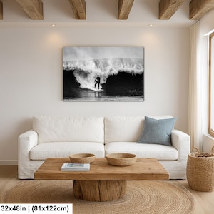 K&ouml;nnte beinhalten: Schwarz-Wei&szlig;-Leinwanddruck eines Surfers auf einer Welle. Das rechteckige Kunstwerk h&auml;ngt an einer wei&szlig;en Wand &uuml;ber einem wei&szlig;en Sofa. Die Ma&szlig;e des Drucks betragen 81x122cm.