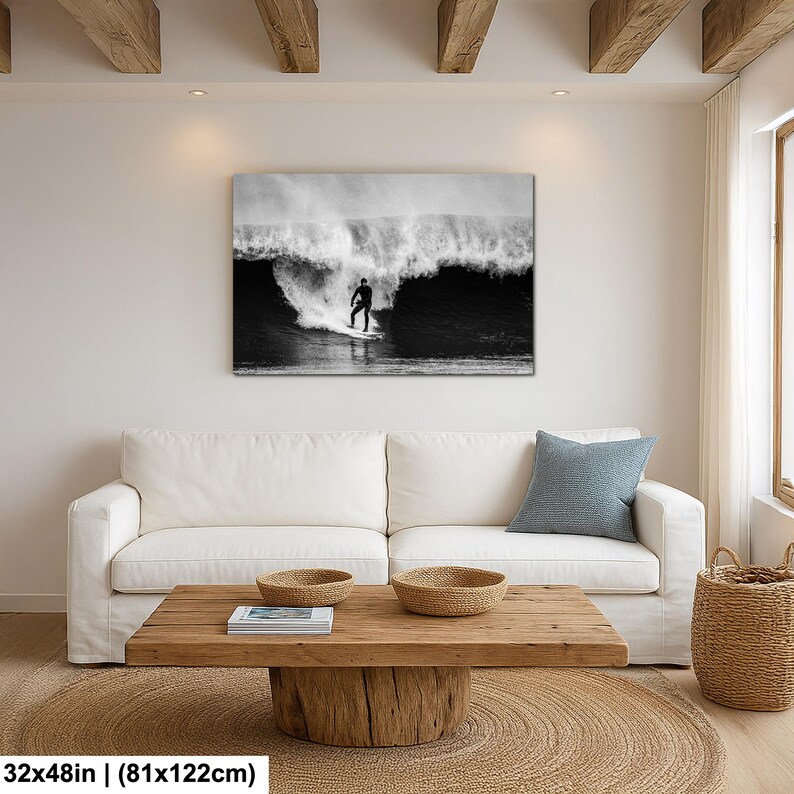 K&ouml;nnte beinhalten: Schwarz-Wei&szlig;-Leinwanddruck eines Surfers auf einer Welle. Das rechteckige Kunstwerk h&auml;ngt an einer wei&szlig;en Wand &uuml;ber einem wei&szlig;en Sofa. Die Ma&szlig;e des Drucks betragen 81x122cm.