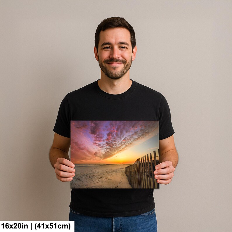 Peut inclure: Impression sur toile de 16x20 pouces (41x51cm) repr&eacute;sentant une plage au coucher du soleil. L'image pr&eacute;sente un ciel vibrant avec des nuances de violet, d'orange et de jaune. Une cl&ocirc;ture en bois longe le c&ocirc;t&eacute; droit, et des empreintes sont visibles sur le sable.