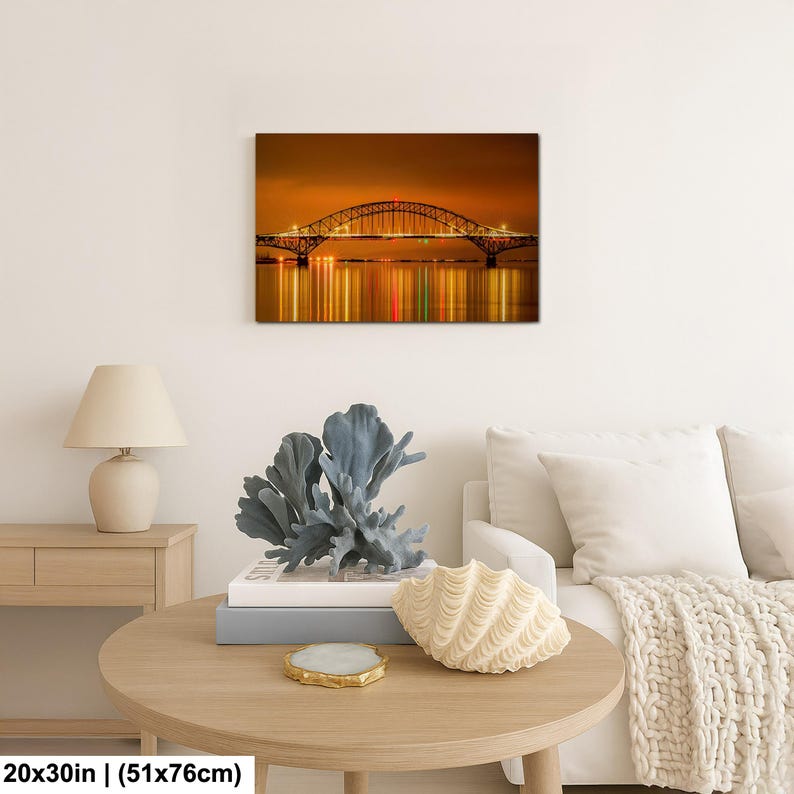 May include: A canvas print of a bridge at night, with the bridge's lights reflected in the water below. The print measures 20x30 inches.