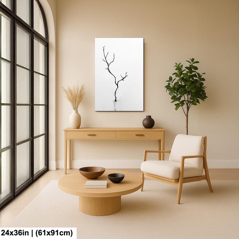 May include: A minimalist black and white canvas art print featuring a bare tree silhouette. The artwork is displayed in a modern living room setting, complemented by neutral-toned furniture and decor. The print measures 24x36 inches.