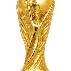 May include: A gold-colored trophy featuring a central figure with arms raised, supporting a globe at the top. The base is circular with two distinct green bands separated by a gold section. The entire structure has a polished, reflective finish.
