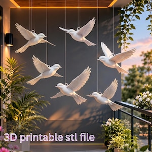 May include: Six white bird sculptures hanging from strings, with outstretched wings. The birds are displayed against a dark grey wall, with the text "3D printable stl file" at the bottom. The scene is set outdoors.