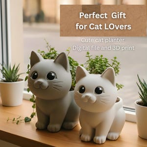 May include: Two cat-shaped planters, one gray and one white, sit on a wooden surface. The planters have large eyes and are filled with greenery. Text on the image reads "Perfect Gift for Cat Lovers" and "Cute cat planter Digital file and 3D print."
