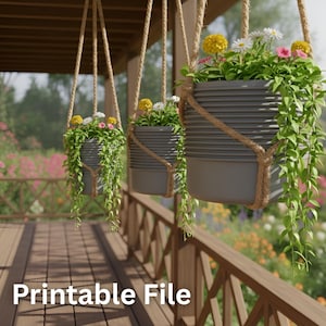 以下が含まれることがあります： カラフルな花と垂れ下がる緑で満たされた、3つの灰色の吊り下げプランター。プランターは木製の構造物からロープで吊り下げられています。画像の下部には「Printable File」というテキストがあります。