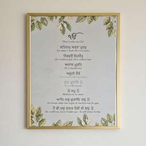 Pode incluir: Uma impressão emoldurada com moldura dourada e fundo cinza claro. A impressão apresenta texto em uma fonte estilizada, com traduções em inglês abaixo. Acentos florais e de folhas adornam a parte superior e inferior.