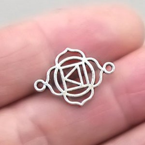 May include: Silver charm with a detailed design of the Anahata chakra, the heart chakra, with a geometric pattern. The charm has two jump rings for attaching to jewelry.