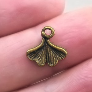 May include: A bronze-coloured ginkgo leaf charm with a loop at the top for attaching to jewellery or other crafts.