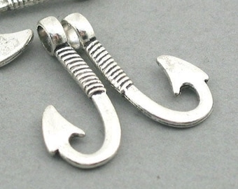 May include: Silver-toned metal fish hook charms. The charms have a curved hook shape with a pointed end and a decorative, ribbed design on the stem. The top of each charm has a small loop for attaching to jewelry.